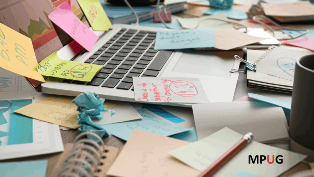 Project management dashboard on laptop screen covered in sticky notes showing information overload and chaos