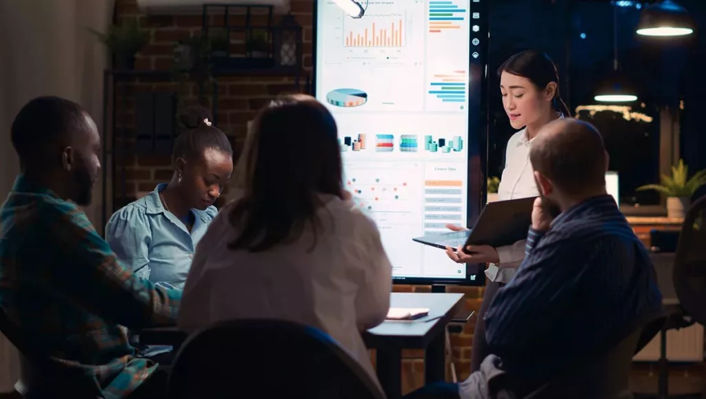 Image of 5 people seated at a table looking at charts 