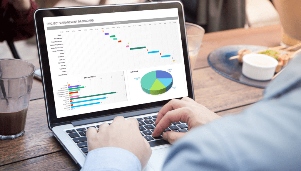 A person sitting at a table using Excel on their laptop.